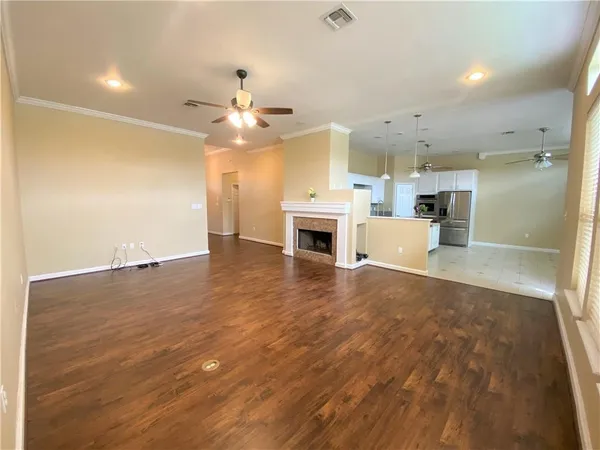 an empty room with kitchen and fireplace