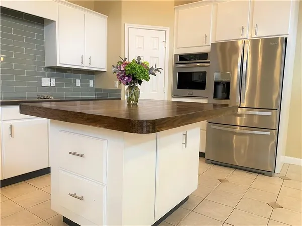 a kitchen with granite countertop white cabinets stainless steel appliances and a counter space