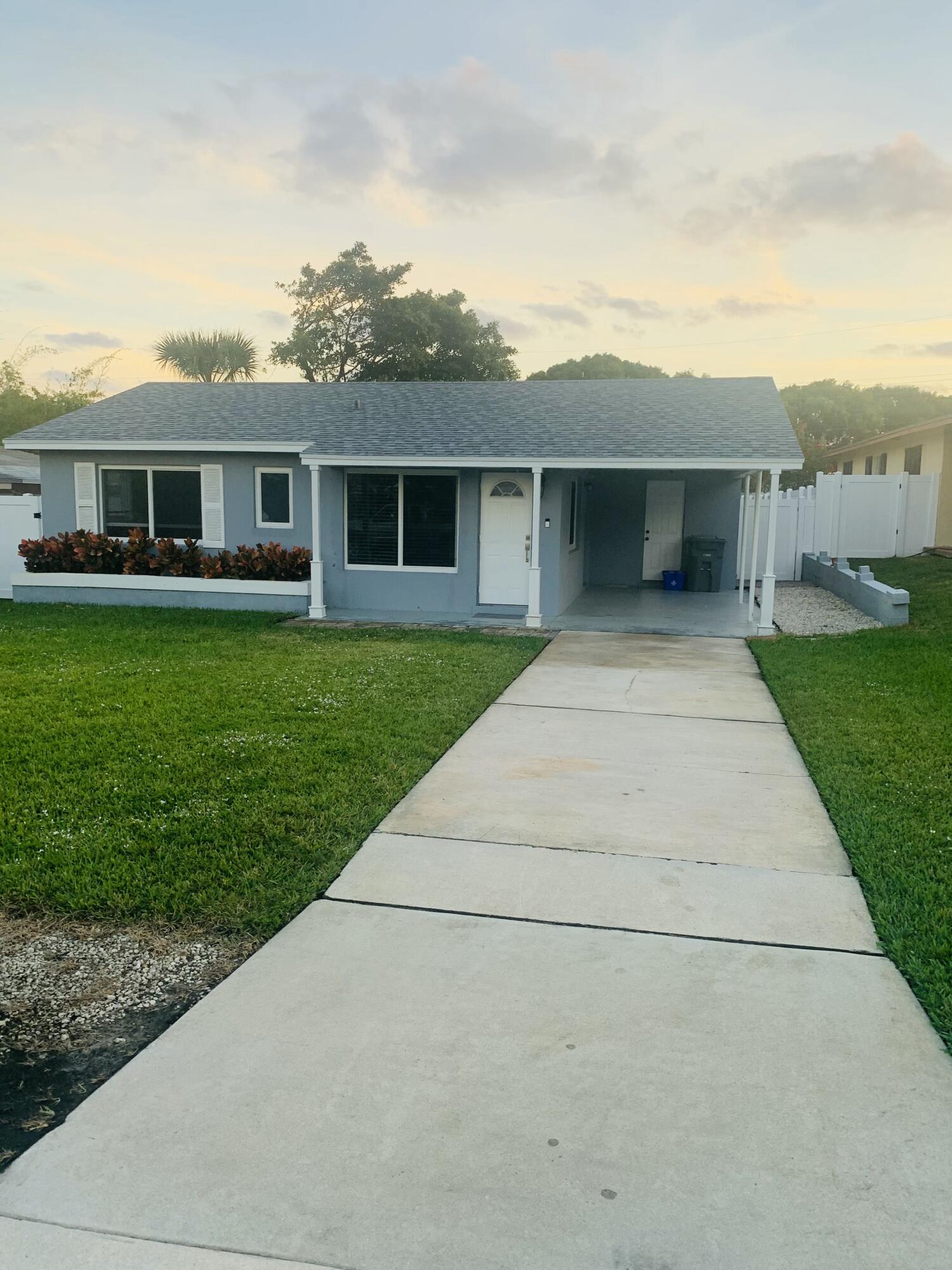 1092 Florence Road Lantana, FL 33462 - Photo 4 of 15 a front view of a house with garden