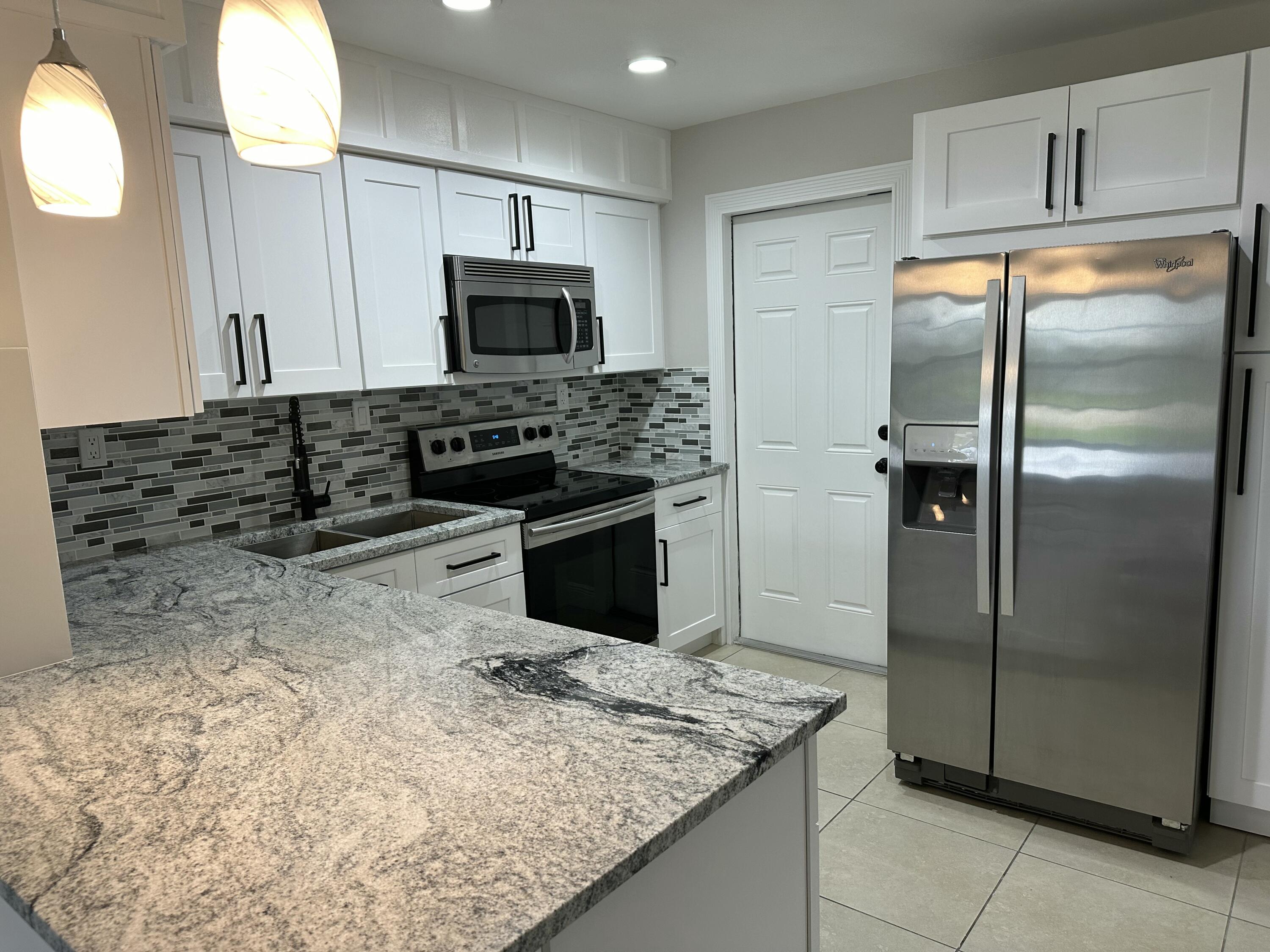 1092 Florence Road Lantana, FL 33462 - Photo 5 of 15 a kitchen with stainless steel appliances granite countertop a refrigerator and a stove