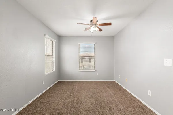 an empty room with a window and a fan