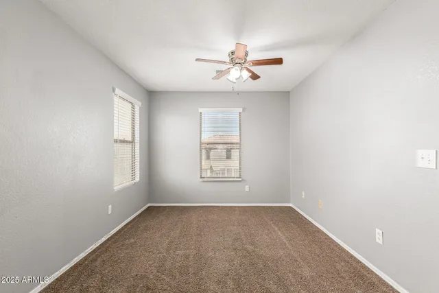 an empty room with a window and a fan