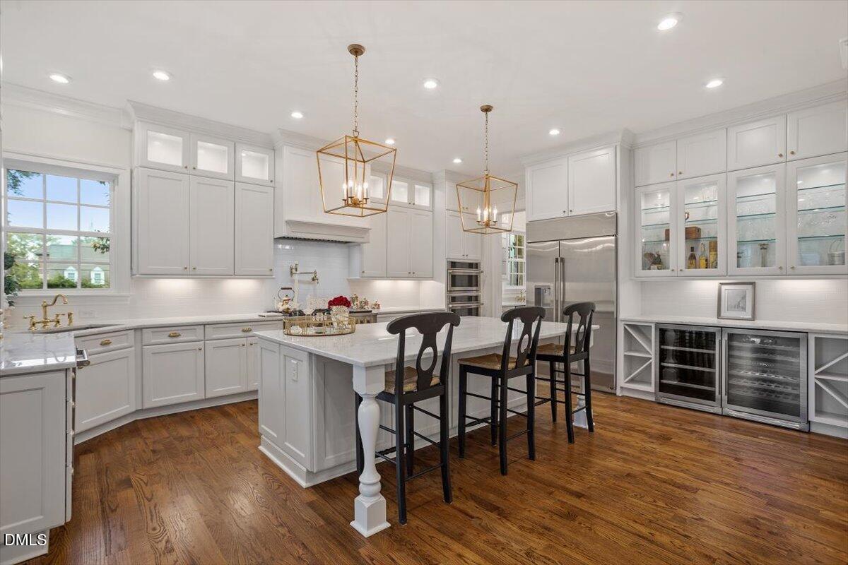 1713 Oberlin Road Raleigh, NC 27608 - Photo 17 of 53 a kitchen with stainless steel appliances granite countertop a stove top oven a refrigerator a sink and kitchen island with wooden floor