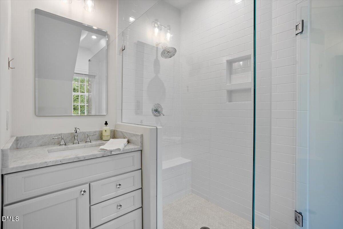 1713 Oberlin Road Raleigh, NC 27608 - Photo 37 of 53 a bathroom with a granite countertop sink a mirror and a shower