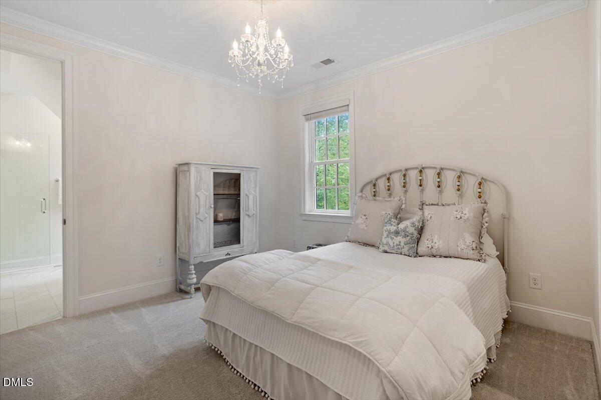 1713 Oberlin Road Raleigh, NC 27608 - Photo 40 of 53 a bedroom with a large bed and a chandelier