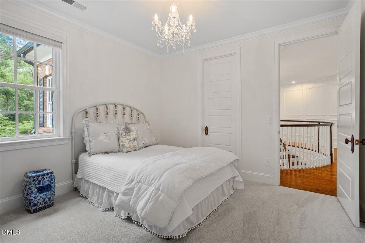 1713 Oberlin Road Raleigh, NC 27608 - Photo 42 of 53 a bedroom with a bed and a chandelier