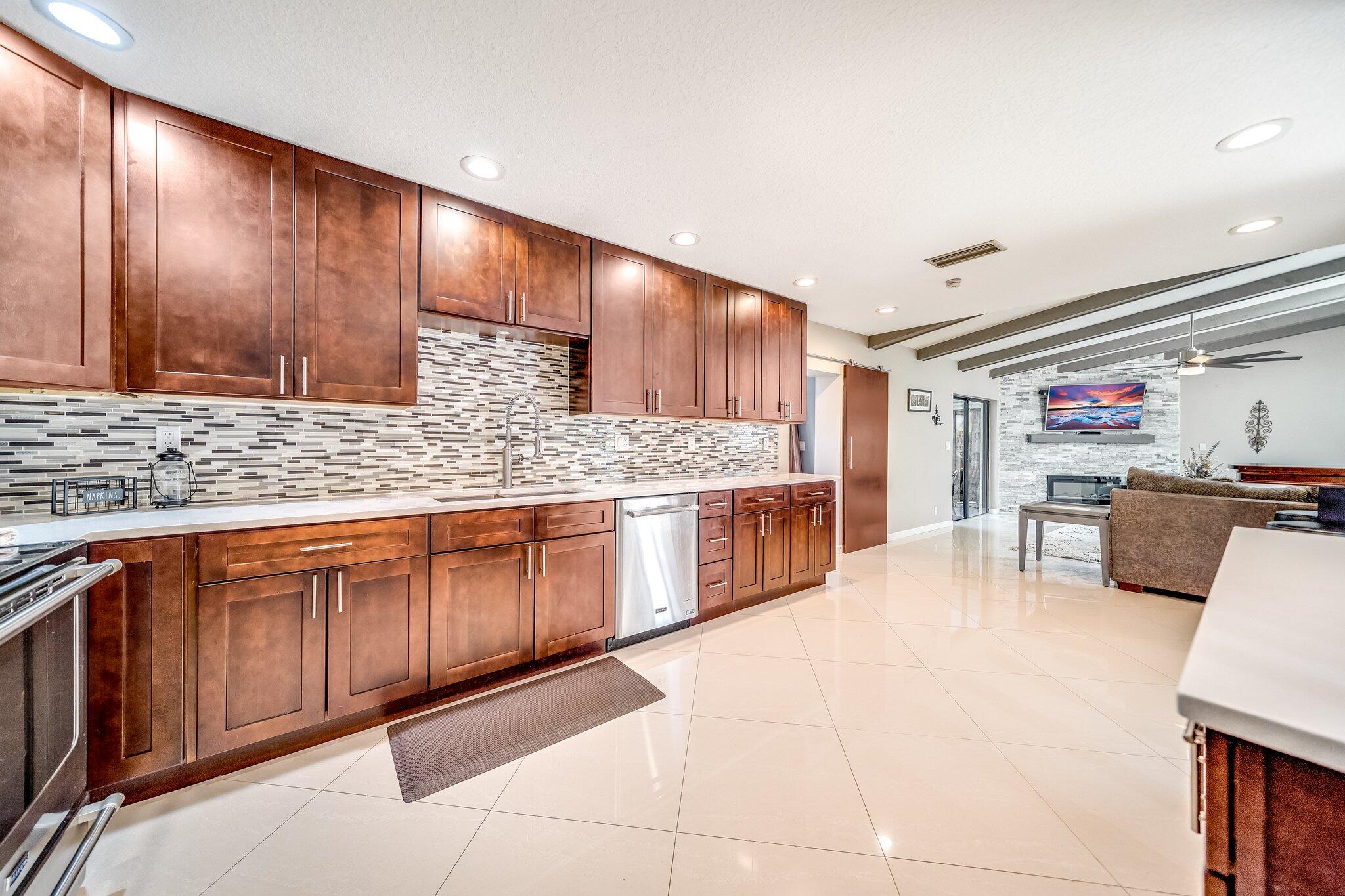 574 Juniper Place Wellington, FL 33414 - Photo 24 of 48 a kitchen with stainless steel appliances wooden cabinets and a counter top space