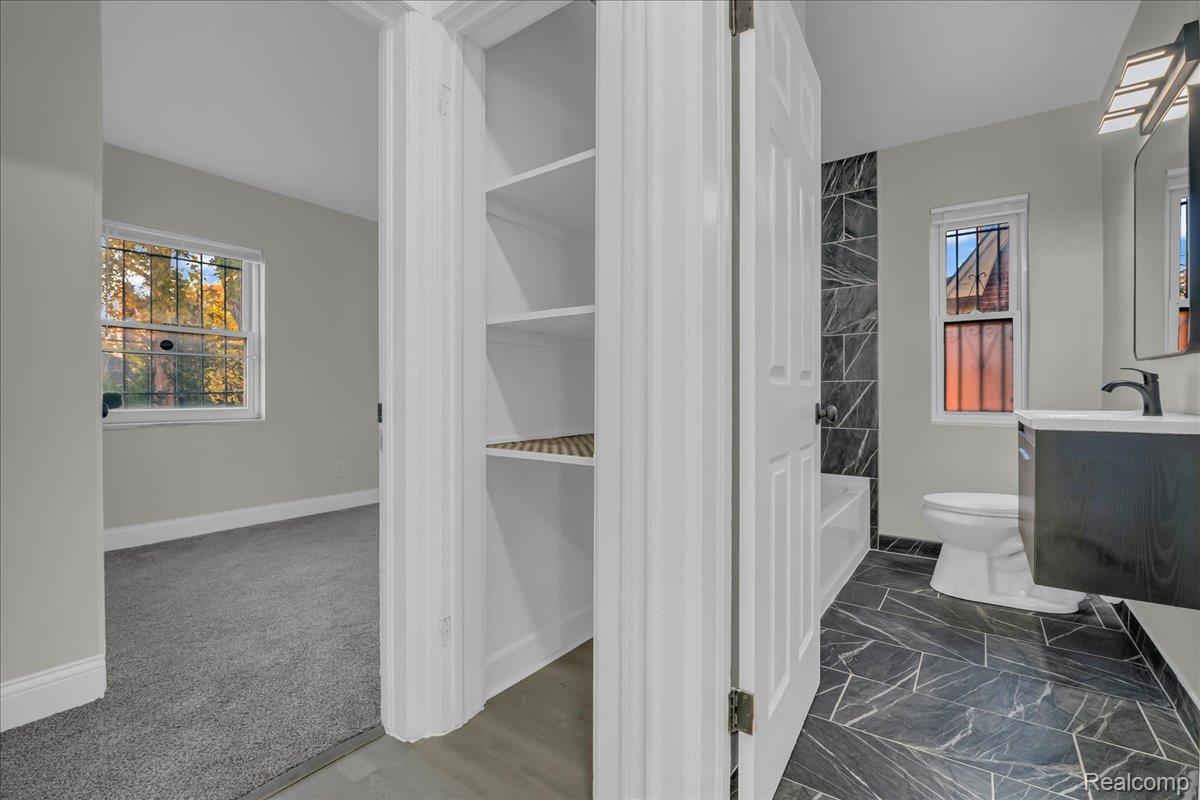 16717 Fielding Street Detroit, MI 48219 - Photo 27 of 46 Full bath with vanity, shower / washtub combination, dark marble finish flooring, and a spacious closet