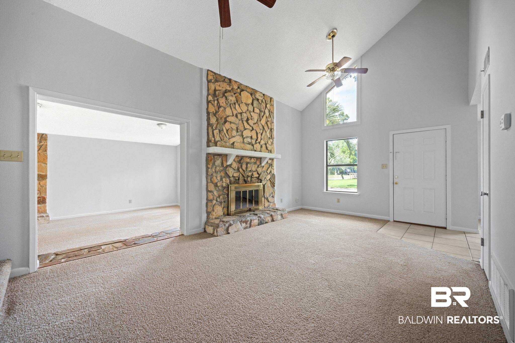 3701 Vista Ridge Drive Mobile, AL 36693 - Photo 9 of 33 Unfurnished living room featuring a fireplace, high vaulted ceiling, ceiling fan, and light carpet