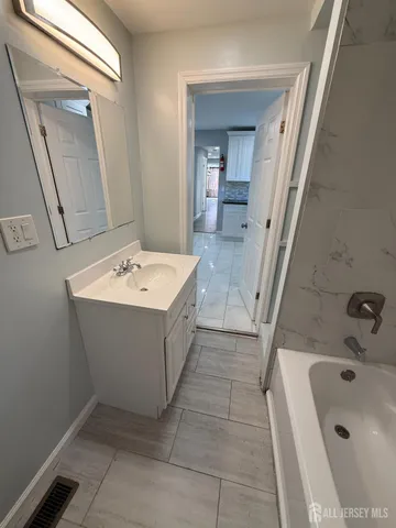a bathroom with a sink a bathtub and a mirror