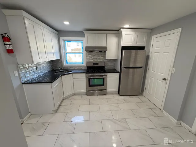 a kitchen with a stove a refrigerator and a sink