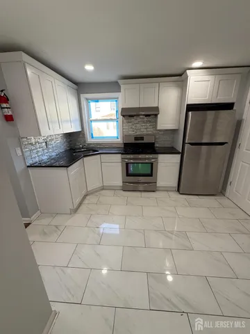 a kitchen with stainless steel appliances a refrigerator sink and microwave