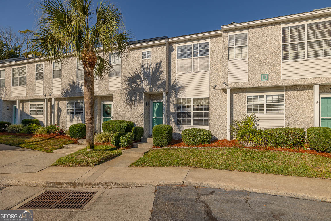 1000 Mallery Street, Unit D27 St. Simons, GA 31522 - Photo 12 of 34 a front view of a house with a yard and garage