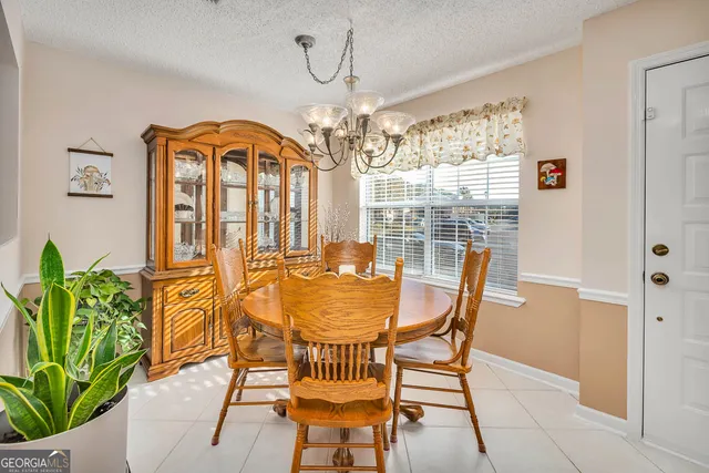 a dining room with furniture a chandelier and wooden floor