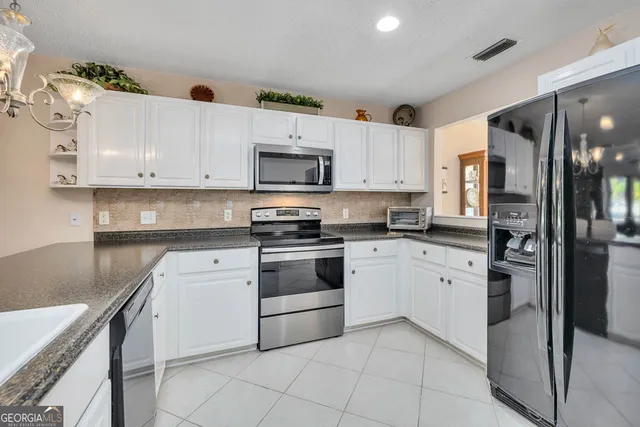 a kitchen with cabinets stainless steel appliances and a counter space