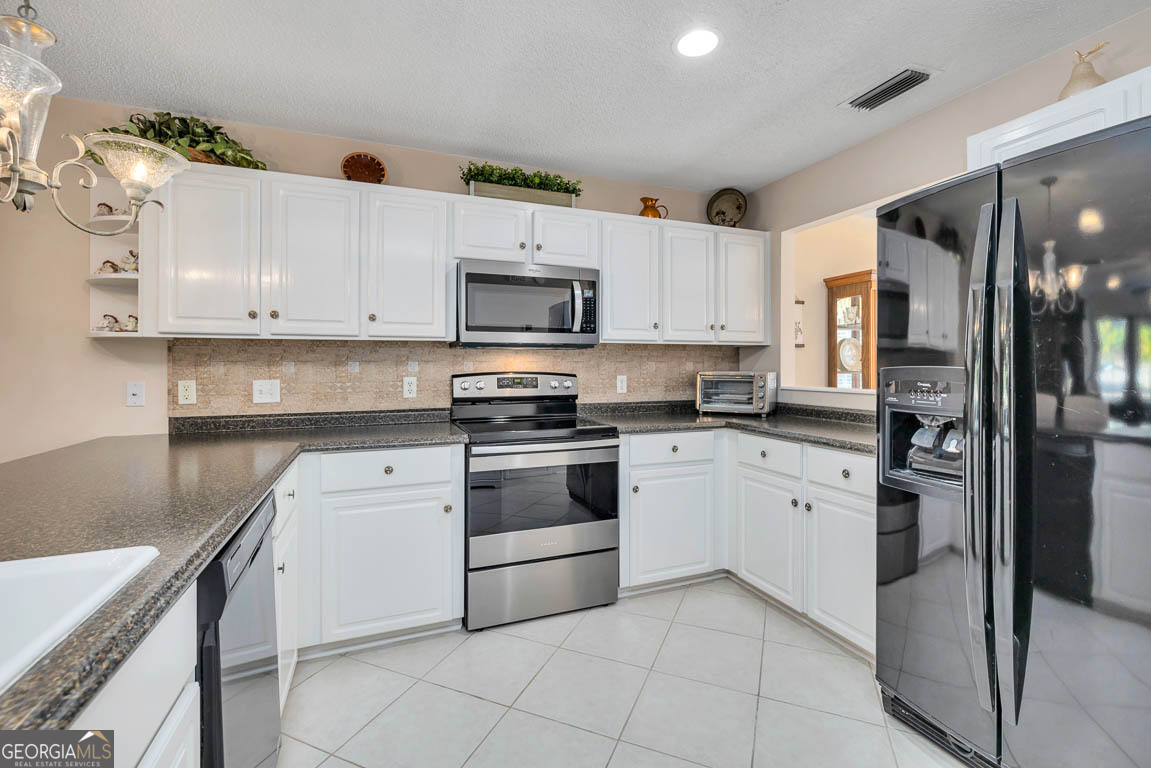 1000 Mallery Street, Unit D27 St. Simons, GA 31522 - Photo 16 of 34 a kitchen with cabinets stainless steel appliances and a counter space