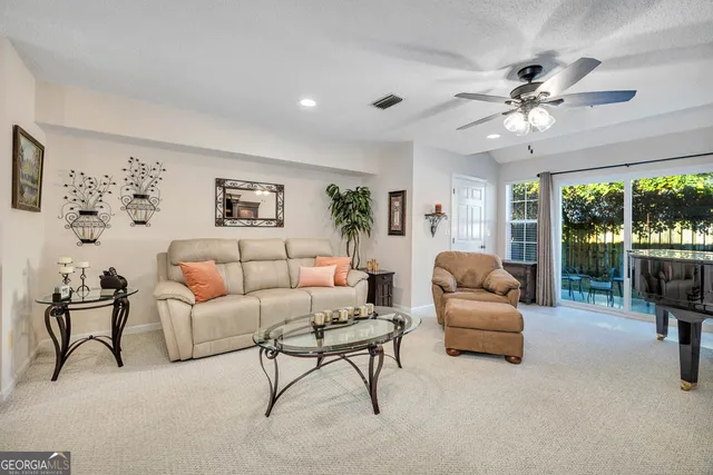 a living room with furniture and a large window with garden view