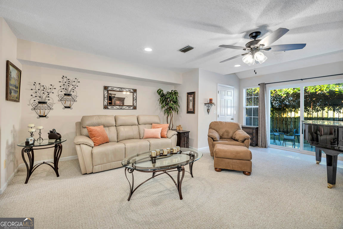 1000 Mallery Street, Unit D27 St. Simons, GA 31522 - Photo 18 of 34 a living room with furniture and a large window with garden view