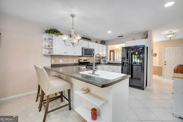 a kitchen with stainless steel appliances granite countertop a sink and a refrigerator