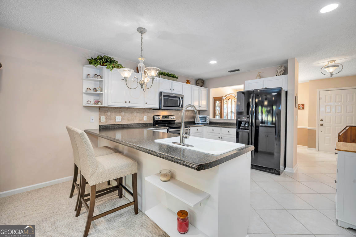 1000 Mallery Street, Unit D27 St. Simons, GA 31522 - Photo 2 of 34 a kitchen with stainless steel appliances granite countertop a sink and a refrigerator