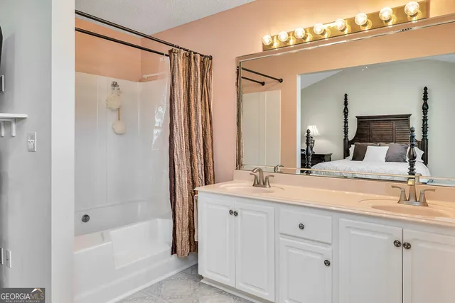 a bathroom with a double vanity sink mirror and shower