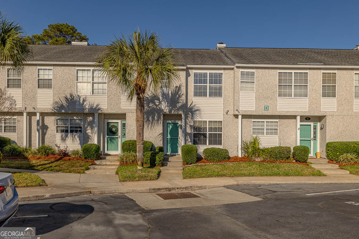 1000 Mallery Street, Unit D27 St. Simons, GA 31522 - Photo 30 of 34 a front view of a residential apartment building with a yard