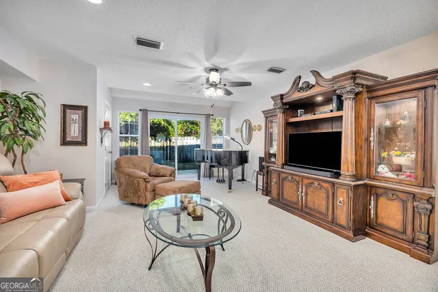 a living room with furniture a flat screen tv and a large window