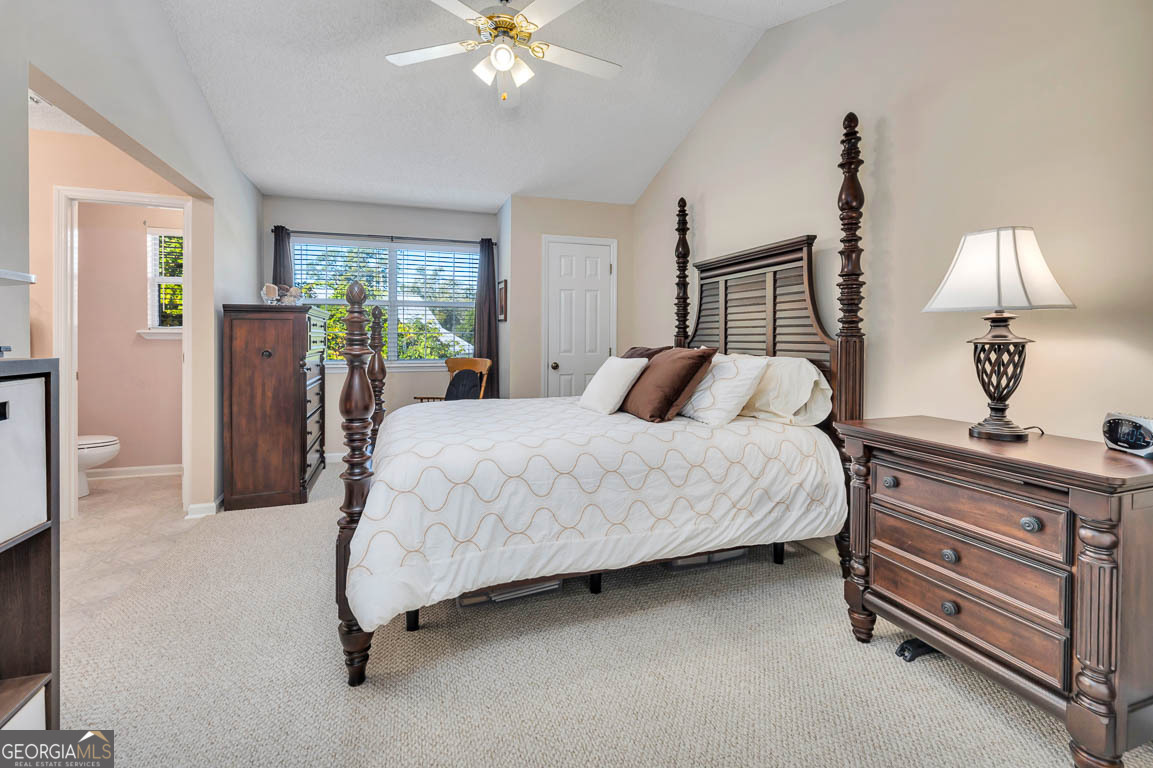 1000 Mallery Street, Unit D27 St. Simons, GA 31522 - Photo 6 of 34 a bedroom with a bed and a chandelier