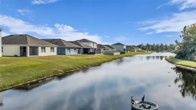 a view of a house with a yard and lake view