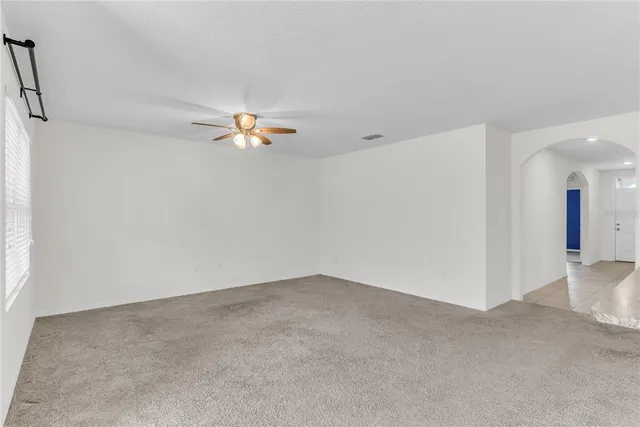 a view of a livingroom with a ceiling fan and window