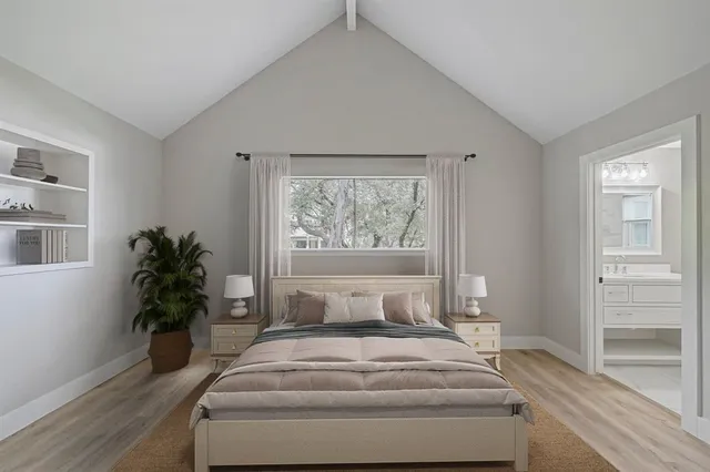 a bedroom with a large bed and a potted plant