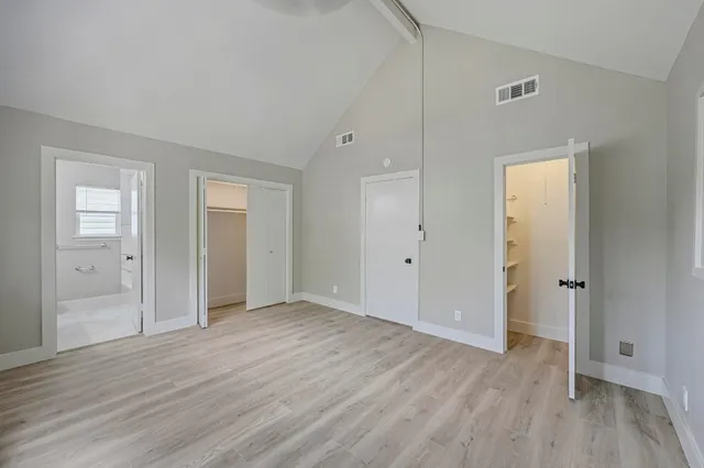 a view of an empty room with wooden floor