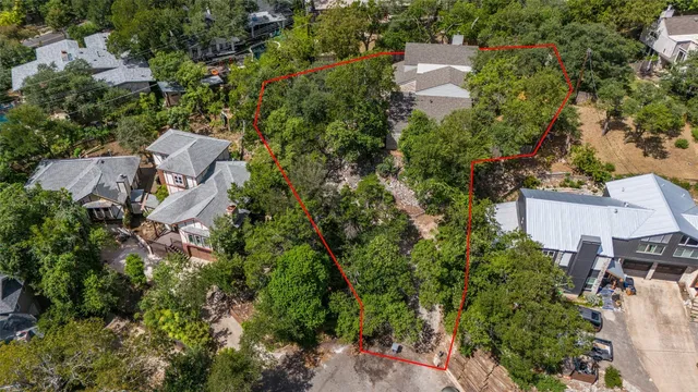 an aerial view of residential house with outdoor space and trees all around
