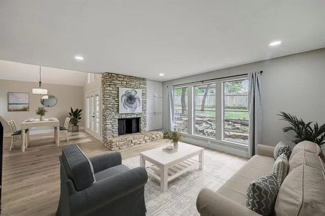 a living room with furniture large window and fireplace