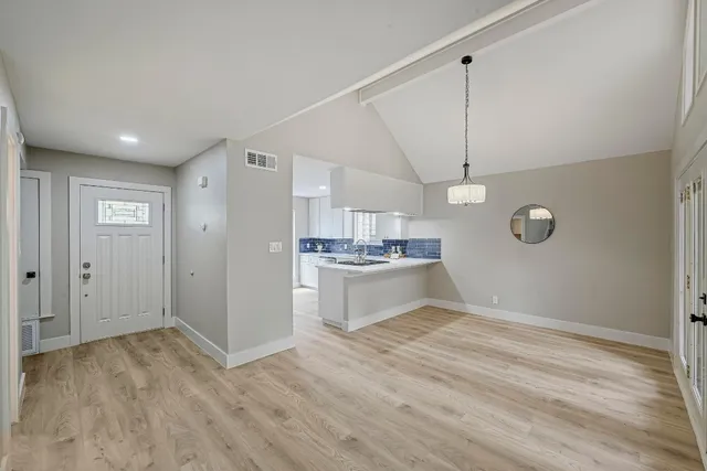 a view of a kitchen with a sink and dishwasher a refrigerator with wooden floor