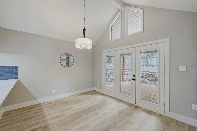 an empty room with wooden floor and mirror