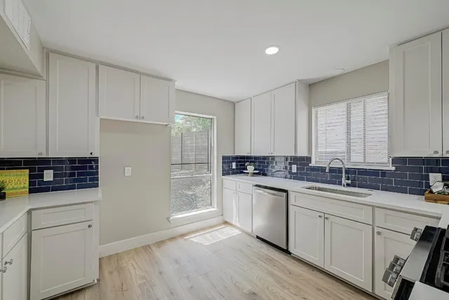 a kitchen with white cabinets and appliances