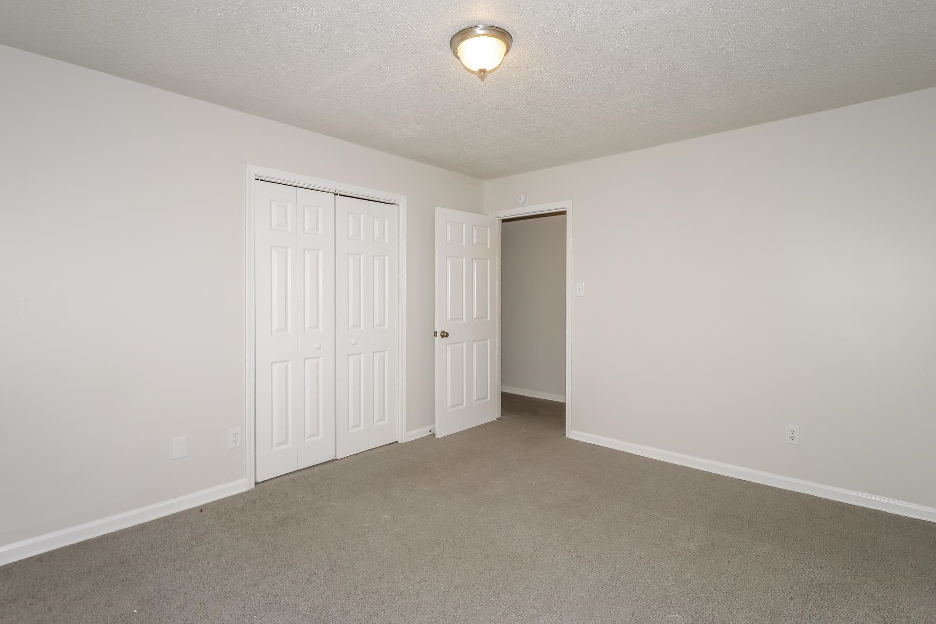 4696 Crestfield Road Millington, TN 38053 - Photo 11 of 17 Unfurnished bedroom featuring a closet, carpet, and a textured ceiling