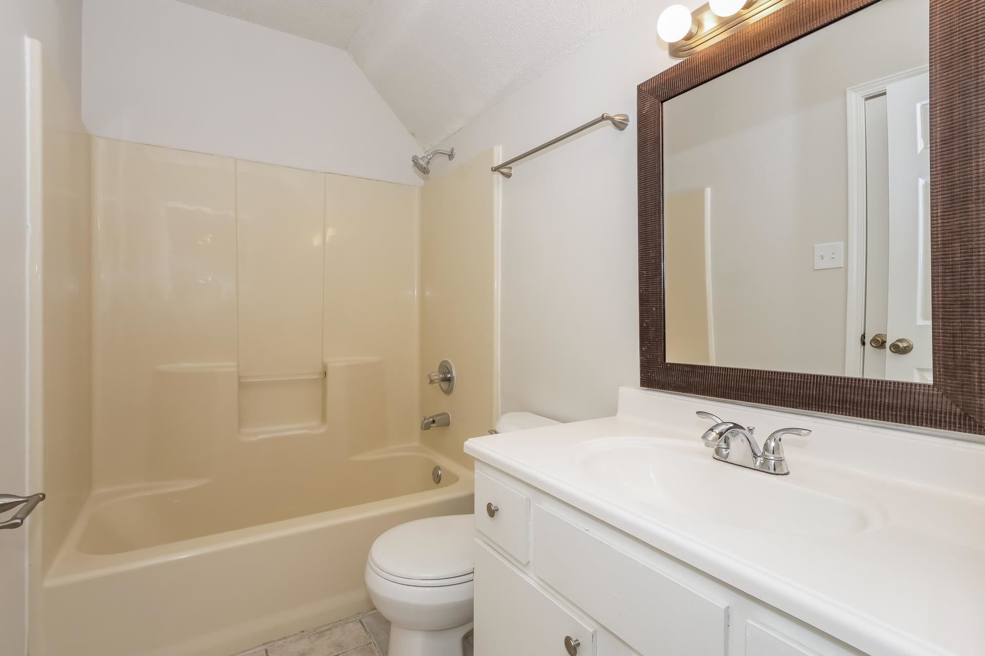 4696 Crestfield Road Millington, TN 38053 - Photo 9 of 17 Bathroom with vanity, bathtub / shower combination, light tile patterned floors, and lofted ceiling