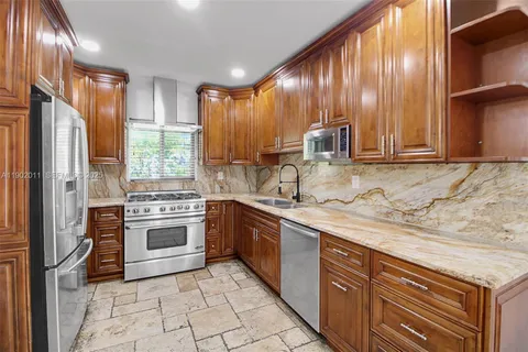 a view of a refrigerator in kitchen and an empty room