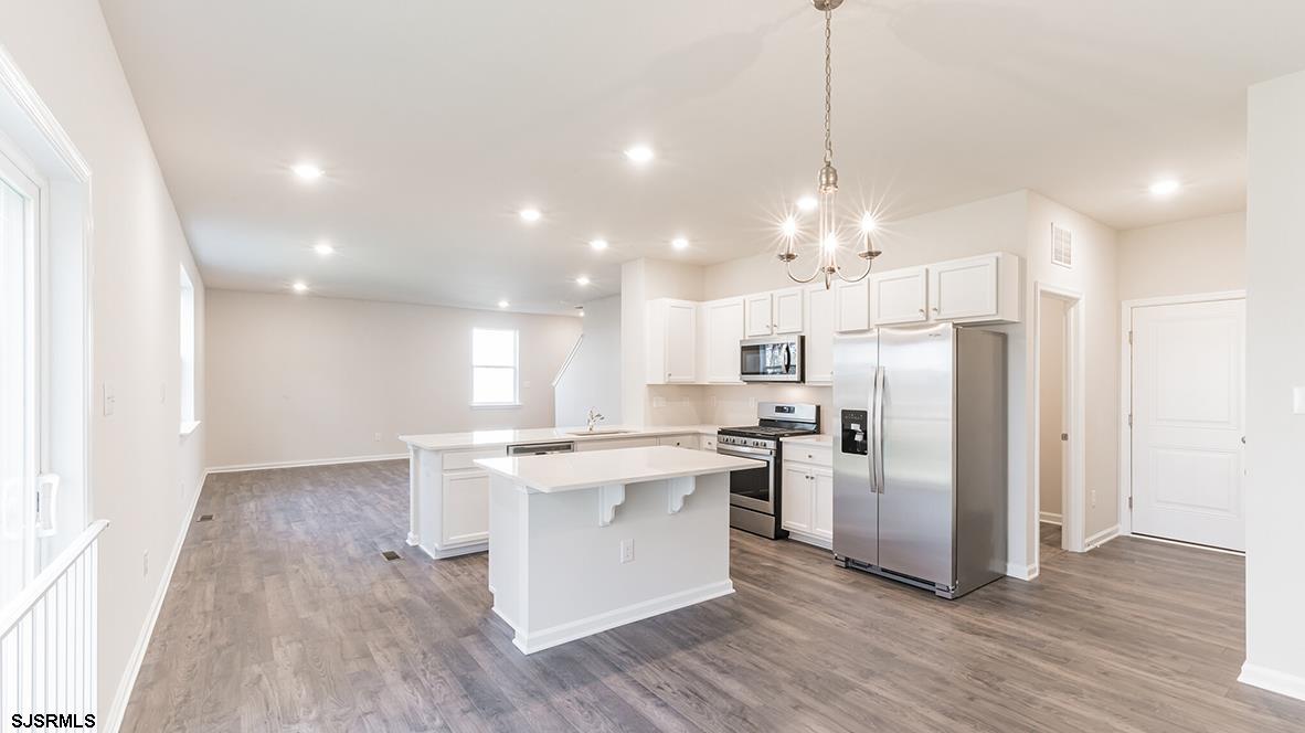 1564 Somers Point Road Egg Harbor Township, NJ 08234 - Photo 5 of 19 a kitchen with stainless steel appliances granite countertop a refrigerator a sink dishwasher a stove and white cabinets with wooden floor