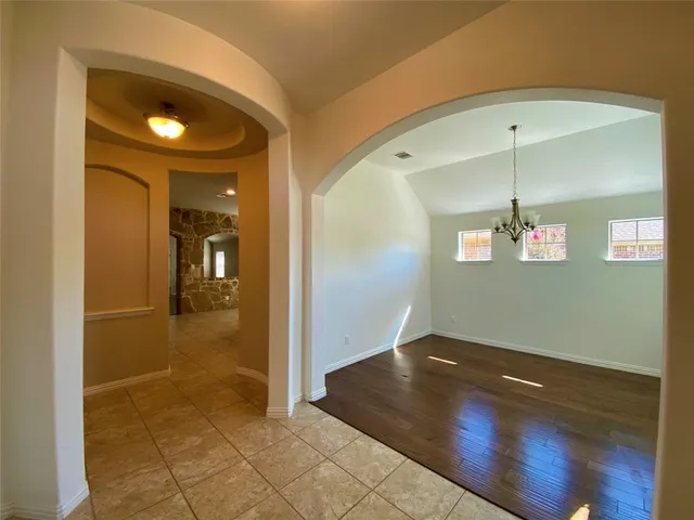 a view of a room with a chandelier fan and windows