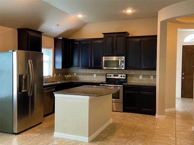 a kitchen with stainless steel appliances granite countertop a refrigerator stove and oven