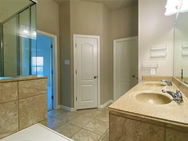 a en suite bathroom with a granite countertop sink and a mirror