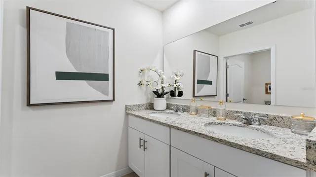 a bathroom with a granite countertop sink and a mirror