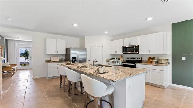 a kitchen with stainless steel appliances a stove a sink a microwave a refrigerator and cabinets