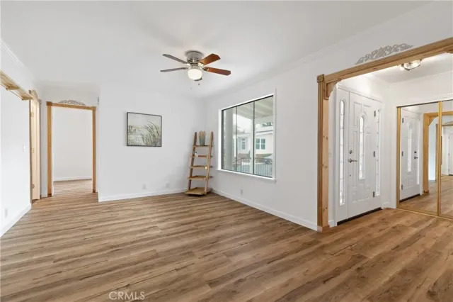 a view of an empty room with window and wooden floor