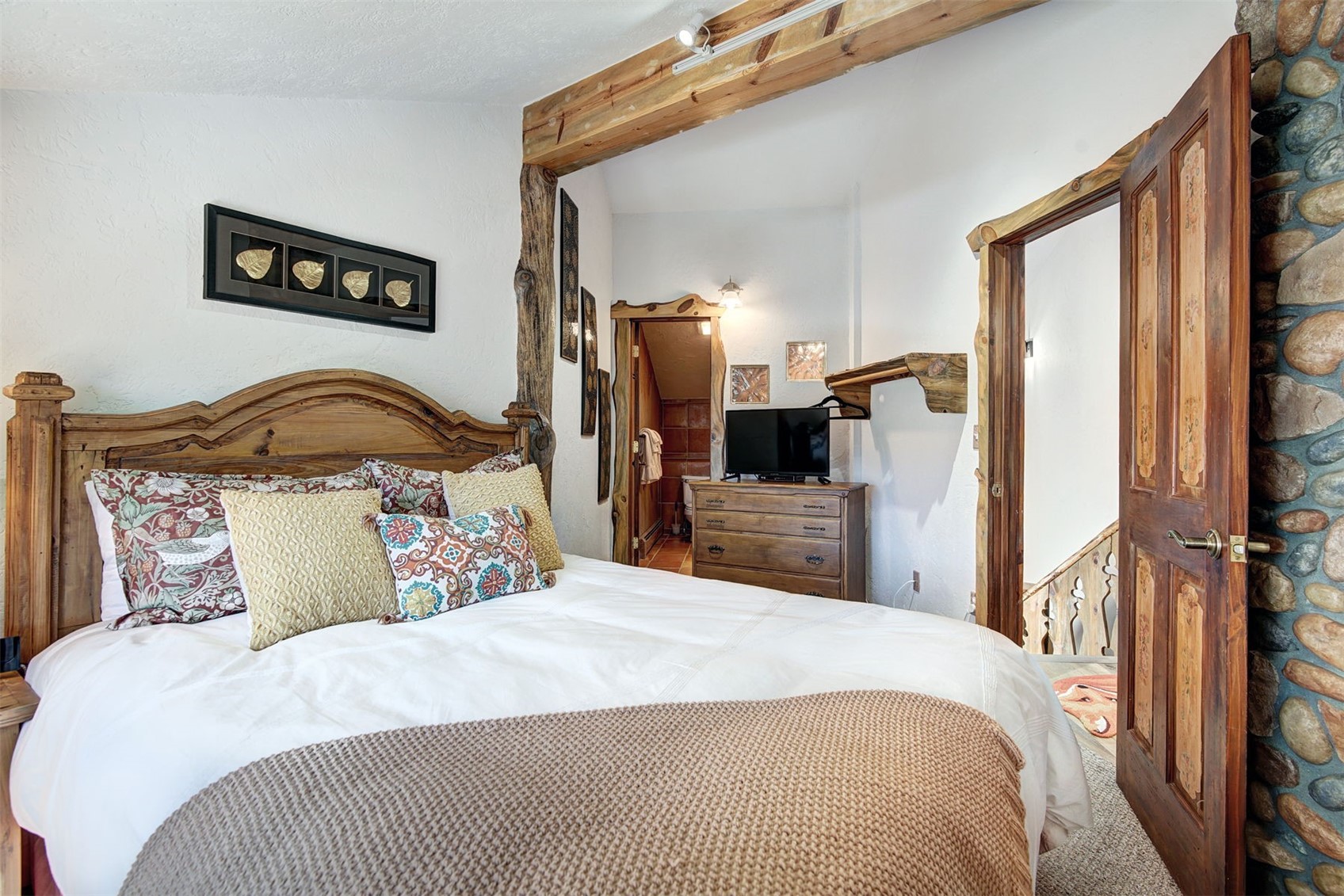 9460 Ryan Gulch Road, Unit 9460 Silverthorne, CO 80498 - Photo 19 of 39 a bedroom with a bed and a large mirror on the dresser