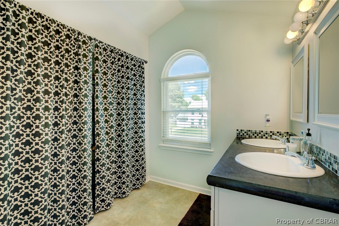 133 Springdale Way Hampton, VA 23666 - Photo 16 of 25 Bathroom with double vanity, lofted ceiling, and tile patterned flooring