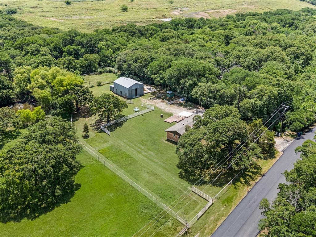 3900 Moseley Road Cross Roads, TX 76227 - Photo 34 of 36 Aerial perspective showcasing a property with a metal-roofed barn, a single-story residence, and extensive green space
